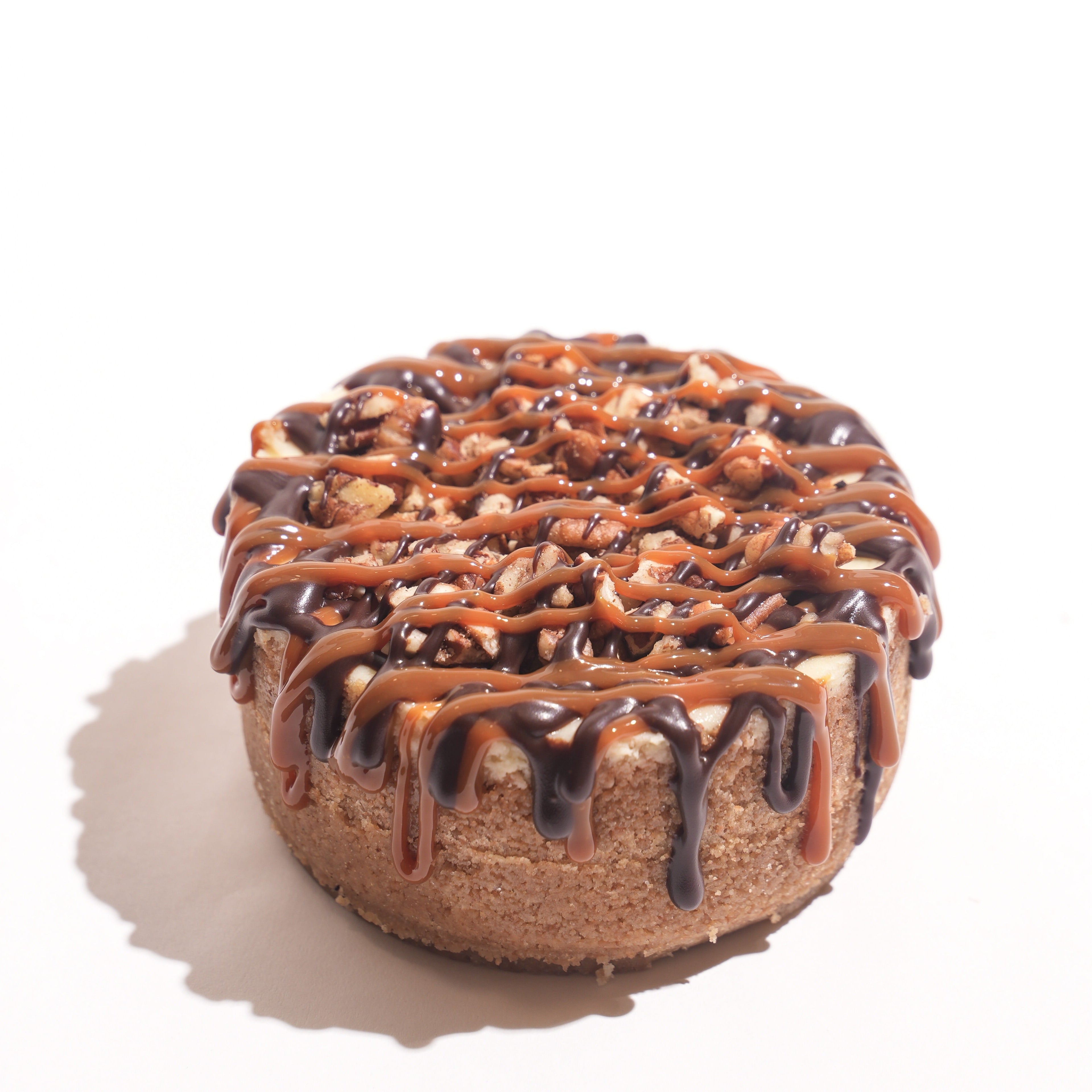 Cheesecake with chocolate and caramel drizzle on a white background